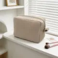 Primer plano de neceser con textura de gofre que muestra detalles en una mesa blanca - Caqui
