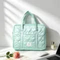 Close-up of mint green heart-quilted laptop bag with handle on white desk - Mint Green