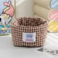 Gros plan d'un panier de rangement en tissu à carreaux marron pour l'organisation du bureau - Marron