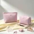 Primer plano de neceseres rosa de tejido gofre con detalle de lazo en un entorno de estilo - Bolso de mano / 20x18x5.5cm / Rosa