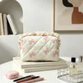 Detailansicht einer cremefarbenen gesteppten Kosmetiktasche mit rosa Schleifenmuster - Weiß mit rosa Schleife / Groß 16x9x9cm