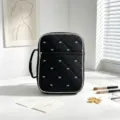 Vista detallada de bolsa de almacenamiento acolchada negra con motivos de lazos blancos. - Negro