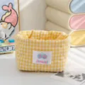 Close-up detail of a yellow checkered quilted fabric storage basket for desk organization - Yellow