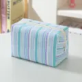 Close-up detail of a blue and white striped seersucker cosmetic bag with white zipper - Blue Striped