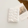 Primer plano del porta pasaporte acolchado con corazones blancos y estuche de viaje - Corazón / Beige