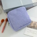 Detalle de un neceser de seersucker a rayas azules y blancas con cierre de cremallera - Azul marino