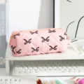 Detailed view of a pink quilted fabric pencil bag featuring black bow patterns on a white desk - Large Capacity / Pink with Black Bow