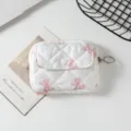 Primer plano de un mini bolso acolchado con lazos rosas y un anillo metálico. - 12*1.5*9cm / Blanco con lazo rosa