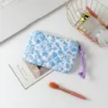 Neceser acolchado con flores azules y detalle de tirador de cremallera en morado - Base Blanca Orquídea Azul