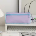 Close-up of a purple and blue canvas pencil pouch with dual zippers on a desk - Purple and Blue