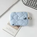 Primer plano de una mini bolsa acolchada azul claro con tirador de cremallera metálico - 12*1.5*9cm / Lazo bordado azul claro