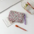 Detalle de un neceser de flores acolchado con tirador de borla morada - Floral Rojo