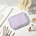 Close-up of seersucker striped cosmetic bag with ruffle edges and purple zipper - Purple