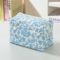 Nahaufnahme der floralen Cord-Kosmetiktasche mit blauem Blumenmuster und feiner Textur - Weiß mit blauen Blumen