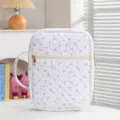 Primer plano de una funda de libro acolchada blanca con estampado de cerezas y cremallera dorada - Funda Para Libros A Mano / Patrón De Cereza Blanca