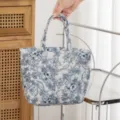 Detalle de un neceser acolchado de gran capacidad con un estampado floral azul - Tamaño: 27*10*18.cm / Estampado Floral Azul Oscuro