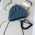 Detail shot of a cute blue fuzzy onigiri coin purse with a black spiral keychain - 13*12cm / Dark Blue
