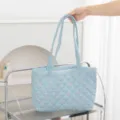 Detalle de bolso tote acolchado de cuadros azul claro con bordado de lazo rosa en estante. - 46*6*27 / Lazo de Cuadros Azul