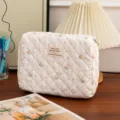 Detailed view of white quilted floral cotton makeup bag with aesthetic fabric patch - M