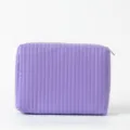 Detailansicht einer lila gesteppten Kosmetiktasche mit vertikalen Nähten und Reißverschluss - 25*7.5*17cm / Lavendel