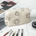 Detalle del neceser de pana beige suave con caras sonrientes bordadas en color negro. - Beige / 16*7*9cm