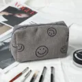Detalle de un neceser de pana gris con caritas sonrientes y textura de rayas suaves. - Gris / 16*7*9cm