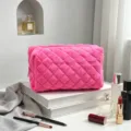 Close-up van felroze gewatteerde badstof cosmetische tas op minimalistische display - Roze