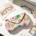 Close-up of cute quilted fabric glasses case with cartoon patchwork and heart button - Cartoon Grid
