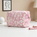 Vista detallada del neceser rosa con estampado de leopardo sobre una mesa blanca - Leopardo Rosa