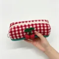 Hand holding a red and white checkered wool pouch with cute crochet cherry decor - Long Pencil Case (Tweed Red Plaid)