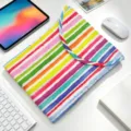 Vista superior de una funda acolchada para portátil con rayas de colores en mesa blanca. - 11" / Arcoíris