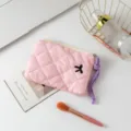 Vista detallata de un mini neceser de maquillaje rosa acolchado para lápiz labial - Tela Rosa con Lazo Bordado