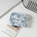 Primer plano detallado de una funda acolchada de flores para auriculares con bolsillo de botón - 12*1.5*9cm / Estampado Floral Azul Oscuro