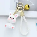 Cute white resin rabbit keychain featuring knitted texture and a small golden bell charm - White Rabbit / White Rabbit