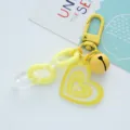 Close-up of a yellow heart-shaped acrylic keychain with a bell and glitter finish. - Heart Bell (F271-6) / Single Pack / Yellow