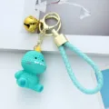 Cute turquoise resin dinosaur keychain with knitted texture and golden bell detail - Blue Dinosaur / Blue Dinosaur