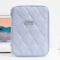 Front view detail of lavender quilted 11-inch tablet sleeve on a white office desk. - Blue