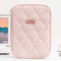 Minimalist quilted pink tablet sleeve for 11-inch iPad shown in a bright office setup. - Pink
