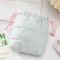 Gros plan d'un sac à cordon matelassé bleu avec des surpiqûres en forme de nuages doux - Bleu clair nuage matelassé