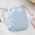 Gros plan sur le matelassage en cœur et le cordon rose d'un sac photo à carreaux bleus - Carreaux de coeur bleu matelassé