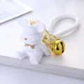 Macro view of white resin bear keychain featuring embossed Lucky text and a gold bell charm - White
