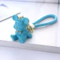 Detailed close-up of a blue resin bear keychain with Lucky engraving and woven strap - Blue