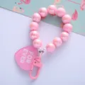 Close-up detail of pink pearlescent beads and heart-shaped tag on a stylish keychain - Pink