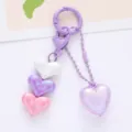 Close-up detail of acrylic heart keychain featuring colorful pastel peach heart pendants - Purple