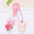 Detailed macro shot of colorful iridescent acrylic heart charms on a pink keychain accessory - Pink