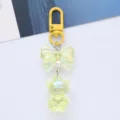 Close-up detail of a dreamy iridescent acrylic bear keychain featuring a gradient bow - Yellow