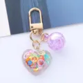 Detailed view of a heart-shaped acrylic keychain with colorful sequins and a purple ball. - Purple