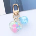 Close-up of cute colorful acrylic heart keychain with blue charm for bag decoration - Blue
