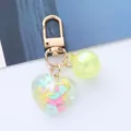 Close-up of colorful heart acrylic keychain with faceted pendant and gold clasp - Yellow