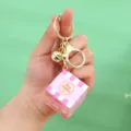 Close-up of pink cartoon Rubik's cube keychain with gold bell and ring - Pink